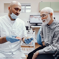 Patient listens as dentist explains denture creation process