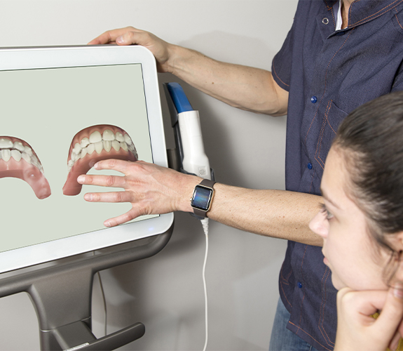 Dentist and patient looking at Invisalign digital treatment plan on computer