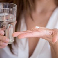 Woman take an OTC pain reliever