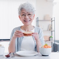 Older lady wearing glasses and enjoying a meal