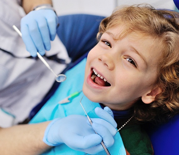 Little boy smiling as his teeth are examined
