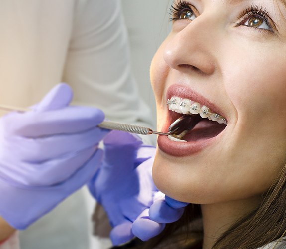 Woman with braces visiting her Lockport orthodontist for checkup