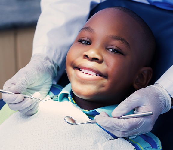 Young boy smiling during children's dentistry checkup and teeth cleaning