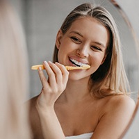 Woman brushing her teeth and smiling