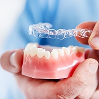 Dentist placing a clear aligner on a mouth mold