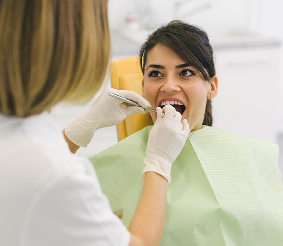 Woman receiving dental checkup to prevent dental emergencies