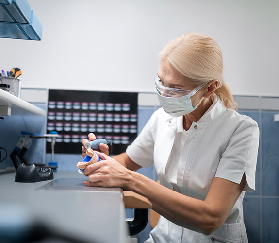 Dental technician crafting replacement teeth