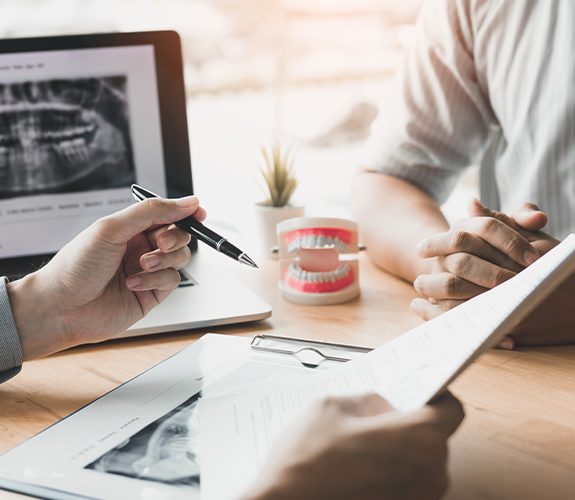 Dentist and patient reviewing dental insurance coverage