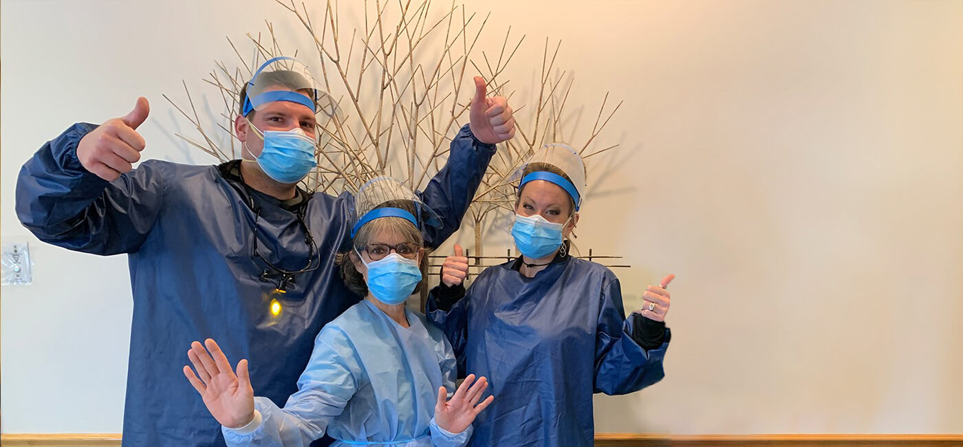 Four dental office team members wearing protective gear