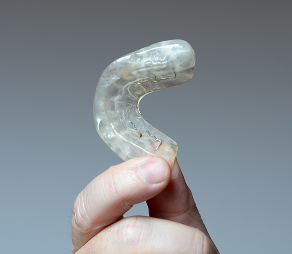 Hand holding occlusal splint for T M J treatment