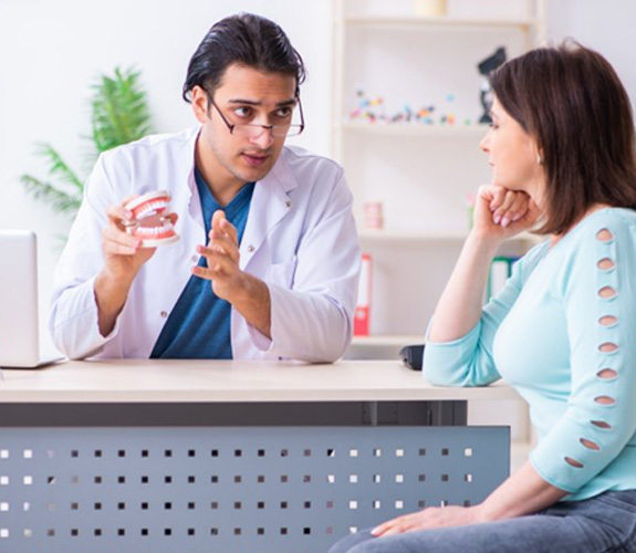 Dentist discussing root canal process with female patient 