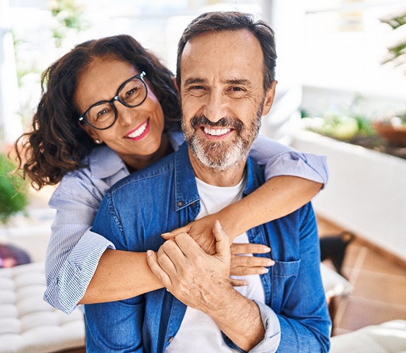 Middle-aged couple after treatment for failed dental implant in Lockport 