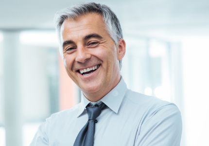 Man sharing flawless smile after replacing missing teeth