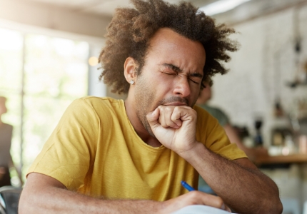 Man in need of sleep apnea therapy yawning