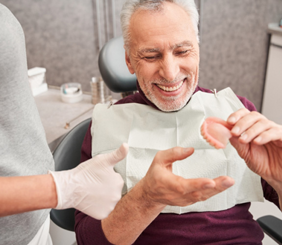Man holding a set of dentures 