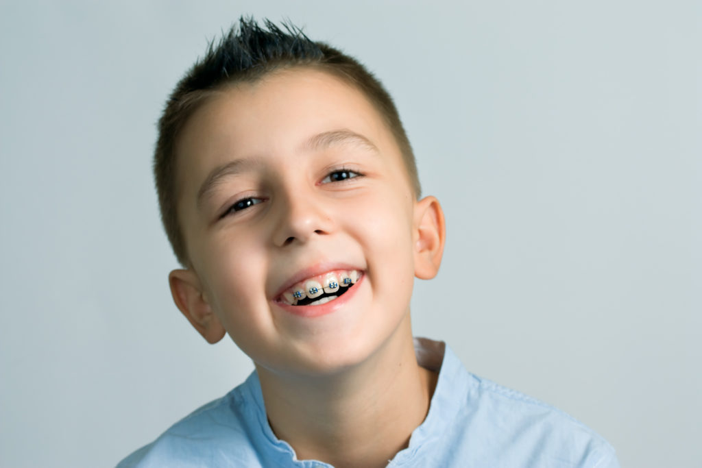 Boy with baby teeth wearing braces