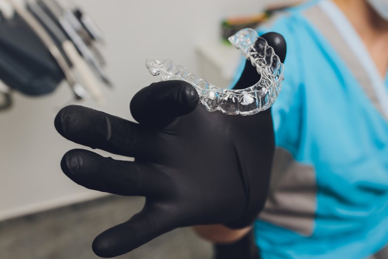 dentist holding an Invisalign aligner