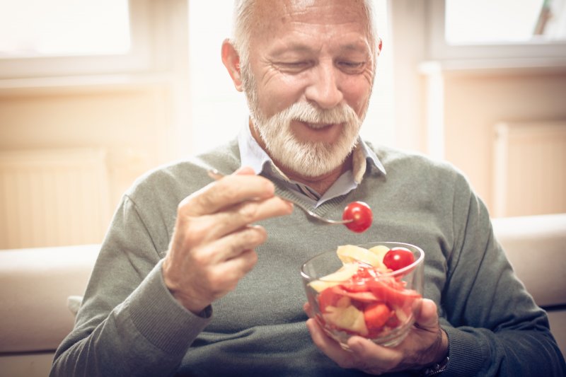 man eating vegetables with dentures