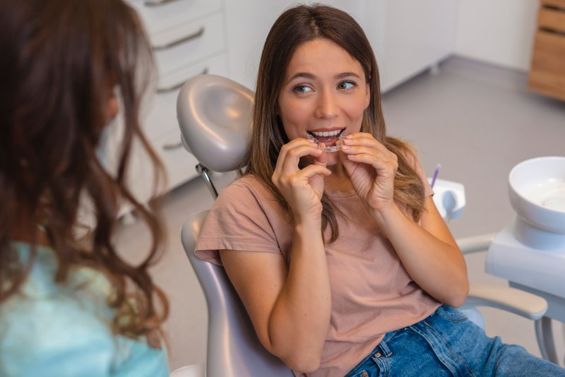 young woman wearing a clear aligner at the dentist’s office