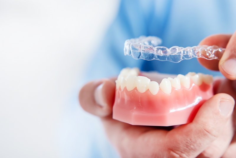 dentist holding mouth mold and clear aligner